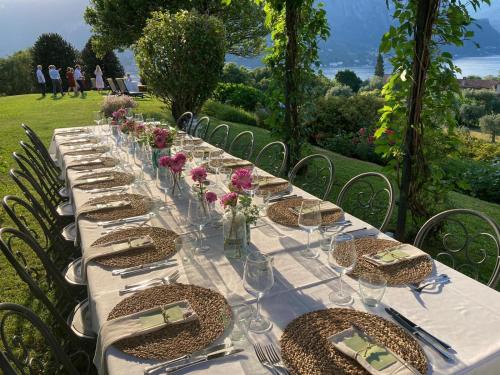 a long table with glasses and flowers on it at Il Poggio Di Bellagio in Bellagio