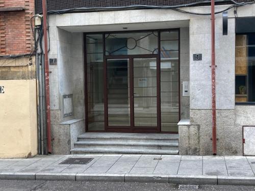 Una puerta de cristal de un edificio con escaleras. en Dúplex CENTRICO LA RANITA SALMANTINA, en Salamanca