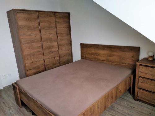 ヴルフラビーにあるHOLLEY Apartment 1623のベッドルーム1室(木製ヘッドボード付きのベッド1台付)