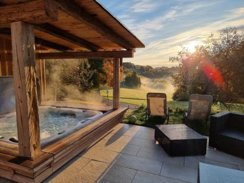 a patio with a jacuzzi tub in a house at Wohlfuehloase am Trausdorfberg mit Sauna/Whirlpool in Sankt Marein bei Graz