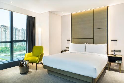 - une chambre avec un lit, un bureau et une chaise dans l'établissement Innside By Melia Zhengzhou, à Zhengzhou