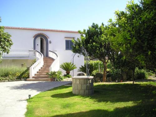 ein weißes Haus mit Treppen und einem Rasenhof in der Unterkunft Casa Ischia in Ischia