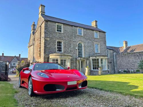 a red car parked in front of a house at Rounceval House in Chipping Sodbury