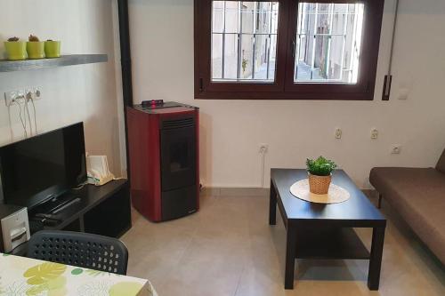 een woonkamer met een bank, een tafel en een tv bij Precioso apartamento en el Pirineo Catalán in La Pobla de Lillet