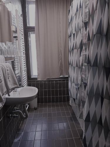 a black and white bathroom with a sink and a tub at Hotel Vojvodina in Novi Sad