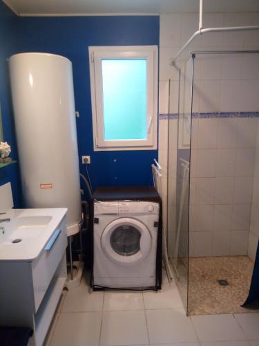 La salle de bains est pourvue d'un lave-linge et d'une fenêtre. dans l'établissement Les Plénitudes du Rivage, à Saint-Vincent-sur-Jard