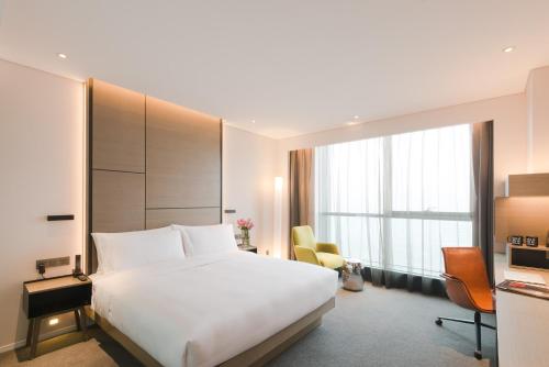 a hotel room with a bed and a large window at INNSiDE by Meliá Zhengzhou in Zhengzhou