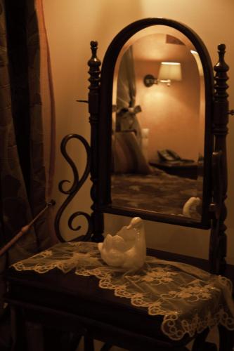 a mirror sitting on top of a chair in a bedroom at Margit Suites Hotel in Karpenision