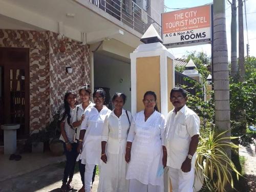 a group of women in white uniforms standing in front of a building at The City Tourist Hotel in Anuradhapura