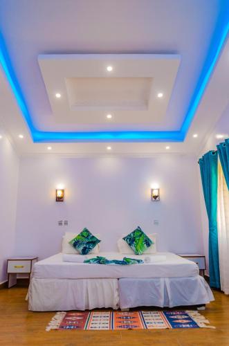 a bedroom with a bed with a blue ceiling at Golden Duranta Villas in Ukunda