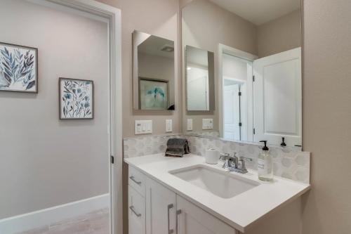 a white bathroom with a sink and a mirror at Bayside Cove Sanctuary in San Diego