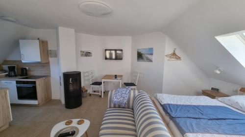 a living room with a bed and a kitchen at Ferienwohnung Rügen 1, Alt Reddevitz 108, Insel Rügen, mit Kamin, Sauna Nutzung möglich in Middelhagen
