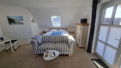 a bedroom with a bed and a table and a window at Ferienwohnung Rügen 1, Alt Reddevitz 108, Insel Rügen, mit Kamin, Sauna Nutzung möglich in Middelhagen
