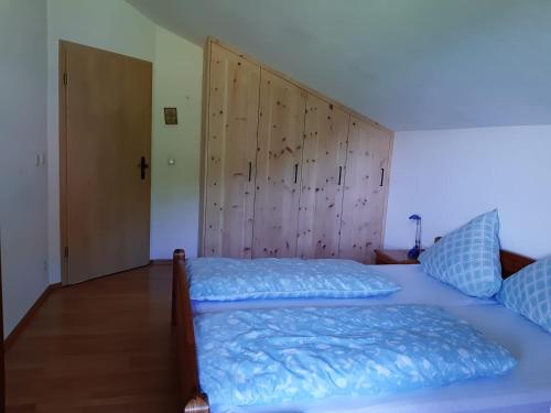 1 dormitorio con 2 camas y cabecero de madera en Haus Maier, en Marquartstein