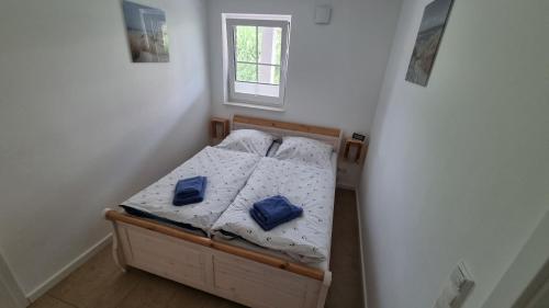 Habitación pequeña con cama con almohadas azules. en Ferienwohnung Rügen 2, Alt Reddevitz 108, Insel Rügen, Sauna Nutzung möglich, en Alt Reddevitz