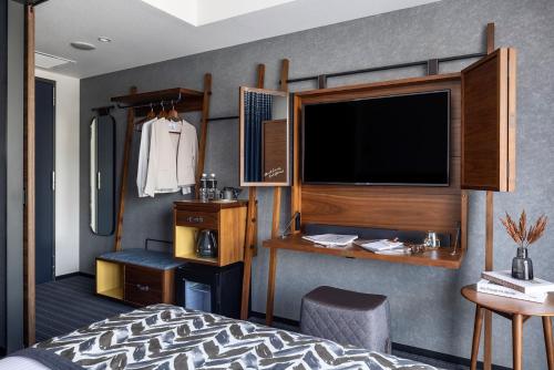 a bedroom with a tv and a bed and a desk at THE LIVELY TOKYO AZABUJUBAN in Tokyo