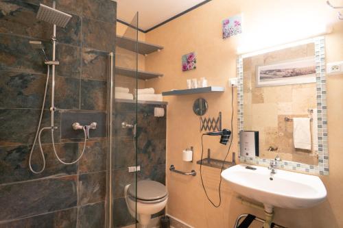 a bathroom with a shower and a toilet and a sink at Le President-Gare Nimes Pont Du Gard in Bellegarde