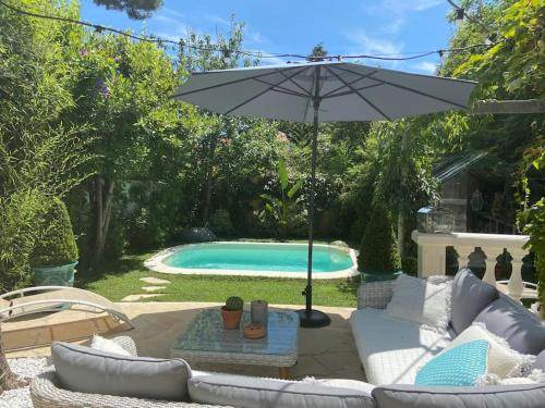 a patio with an umbrella and a swimming pool at Cap d'Antibes 50m from the beach 3 bedrooms/Pool in Antibes