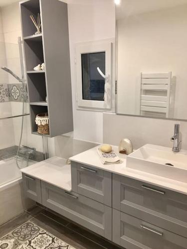 La salle de bains blanche est pourvue d'un lavabo et d'une baignoire. dans l'établissement Cap d'Antibes 50m from the beach 3 bedrooms/Pool, à Antibes