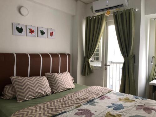 Apartment Grand Sentraland Karawang Manage by Laguna Room tesisinde bir odada yatak veya yataklar