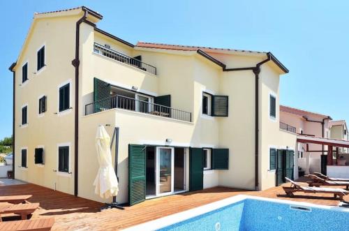 a house with a swimming pool in front of it at Villa royale with shared pool in Hvar