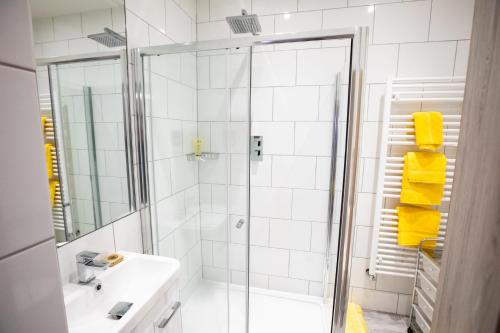 ein weißes Bad mit einer Dusche und einem Waschbecken in der Unterkunft Nadler House 1 Bed Basement Apartment in Norwich