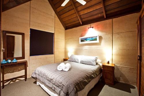 a bedroom with a bed with two towels on it at Whalers Cove Villas in Dunsborough