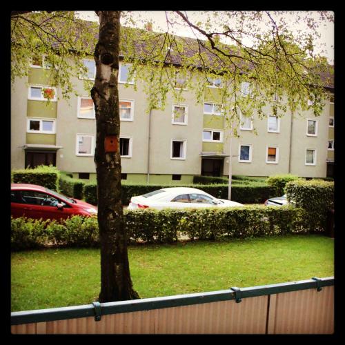 a building with cars parked in front of a tree at Ferienwohnung Ana in Hannover