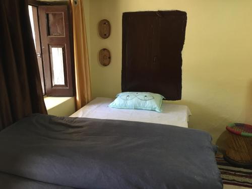 una camera da letto con un letto con un cuscino sopra di Katyuri Kings Divine Homestay- Babaji's cave a Dwārāhāt