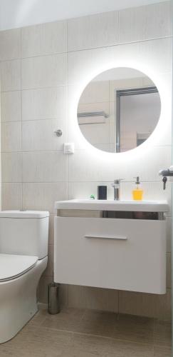 a white bathroom with a sink and a mirror at Giola Hosting in Astris