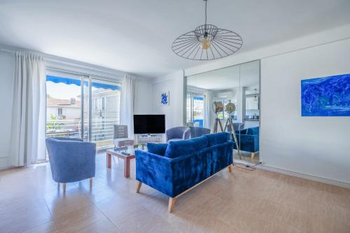 un salon avec un canapé bleu et une télévision dans l'établissement 2Br Apartment 100m from Beaches Terrace & Parking, à Cannes