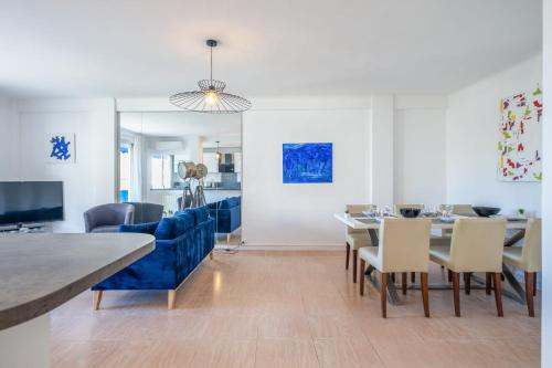 - une salle à manger avec un canapé bleu, une table et des chaises dans l'établissement 2Br Apartment 100m from Beaches Terrace & Parking, à Cannes