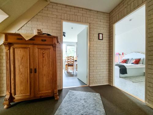 a room with a wooden cabinet and a bedroom at B&B overnachting de Margriet in Hardenberg