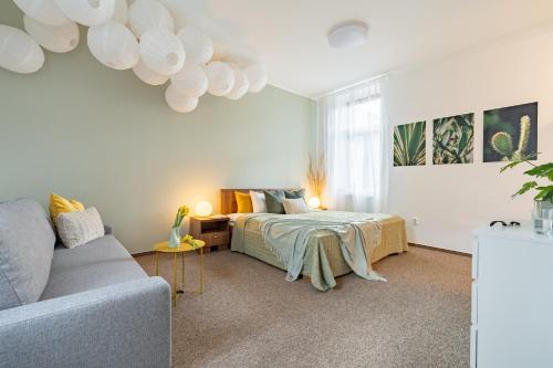 Penzion Expo Dream #33 by Goodnite cz في برنو: غرفة معيشة مع سرير وأريكة