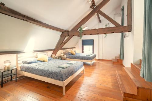 a bedroom with two beds in a room with wooden floors at The Old Town Lodge in the Heart of Antwerp in Antwerp