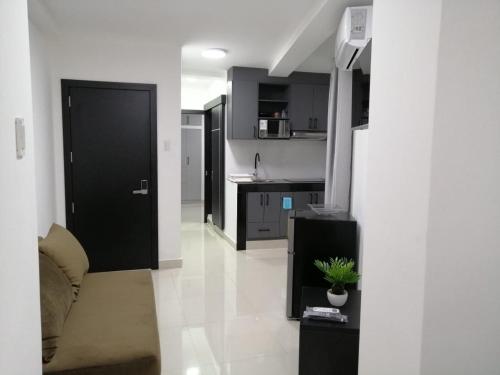a kitchen with a black door and a white floor at UMBRELLA SUITE in Manta