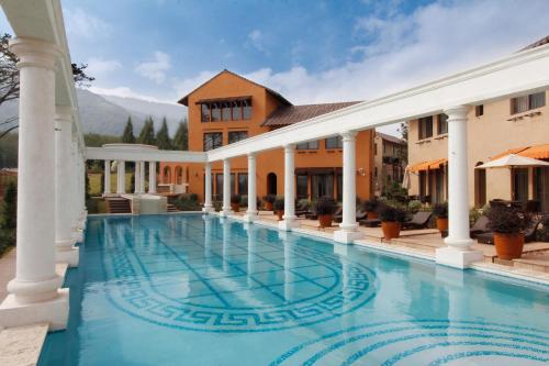 a large swimming pool in front of a house with columns at Toscana Hotel La Casetta in Mu Si