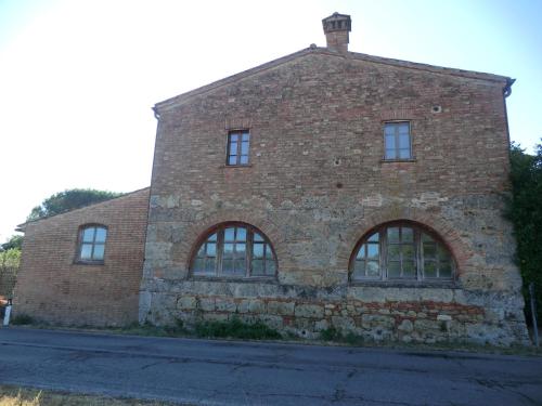 an old brick building with windows on a street at Il casale di Sandra in Chiusi