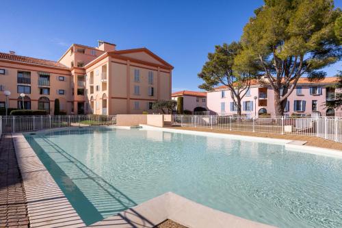 une grande piscine devant un immeuble dans l'établissement Le Sakharov, à Fréjus