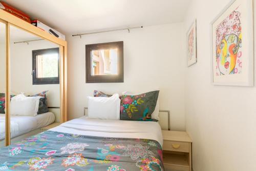 une petite chambre avec un lit et un miroir dans l'établissement Le Sakharov, à Fréjus