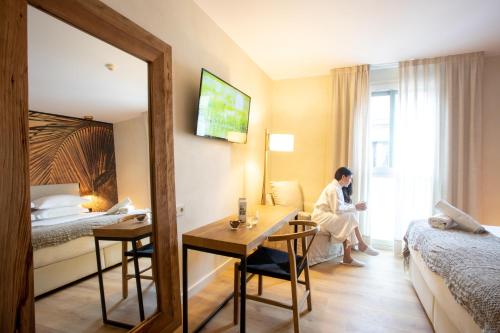 a woman sitting at a desk in a hotel room at Ciutat de Girona in Girona