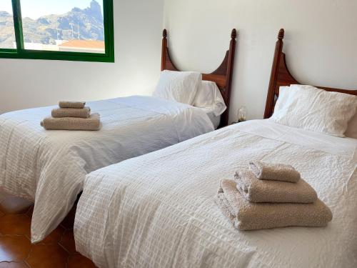 two beds with towels on them in a bedroom at Central House at Tejeda's Heart with Amazing View in Tejeda