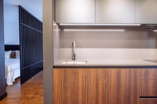 a kitchen with a sink next to a bedroom at Trumpalaikė nuoma Telšiuose in Telšiai