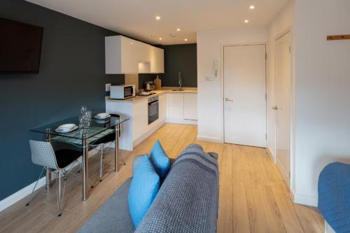 a living room with a couch and a table at Alison Court - Urban Apartments in Bristol