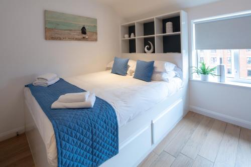 a bedroom with a large bed with a blue blanket at Alison Court - Urban Apartments in Bristol