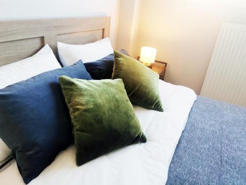 a bed with blue and green pillows on it at 7-Athens new morden comfortable-center,metro,private parking in Athens