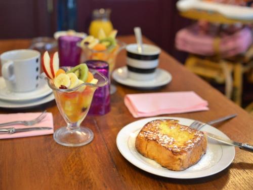 a table with a plate of bread and a drink at Suivez Le Lapin Blanc-BB Chambres d'Hôtes in Saint-Valéry-sur-Somme