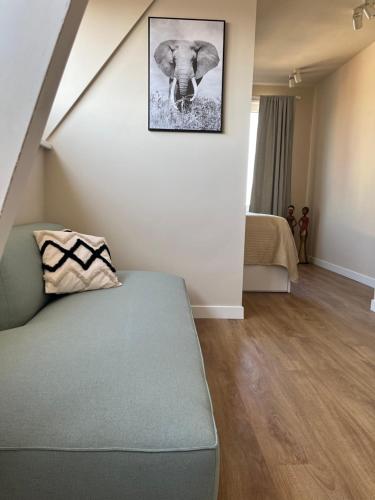 uma sala de estar com um sofá e uma fotografia de um elefante em Weltevreden em Noordwijk