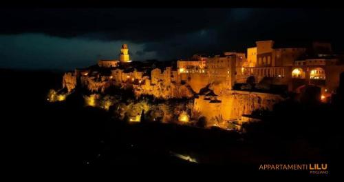 a city lit up at night with a lighthouse at Appartamento Liliana e Ludovica 1 in Pitigliano