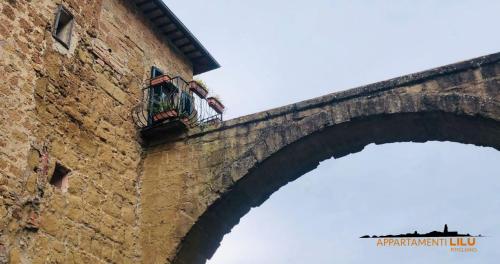 a bridge with a balcony on the side of a building at Appartamento Liliana e Ludovica 1 in Pitigliano